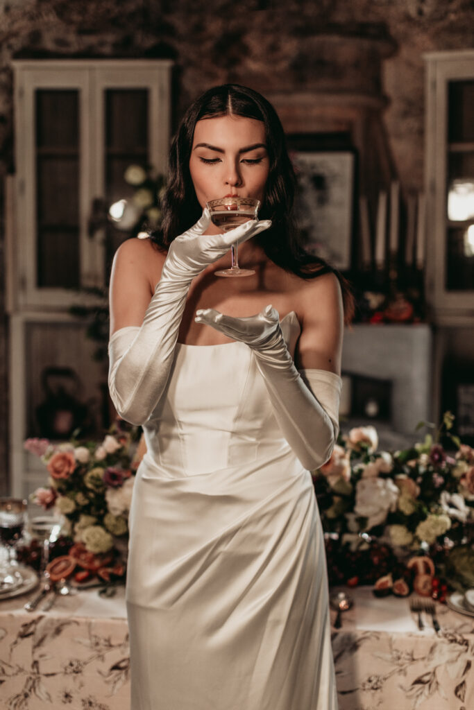 beautiful bridal model posing with champaign glass, wildblooms bridal wedding dress Styled Shoot at Bannerman Castle beautiful details by Hudson Valley wedding vendors