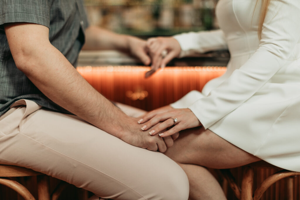 close up photo of couple sitting at bar together.