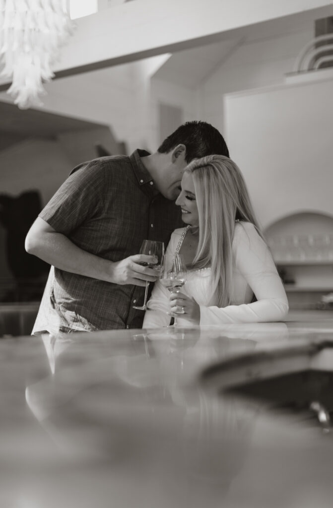 black and white photo of couple hanging our at bar. candid photos of couple laughing and talking while sharing a drink.