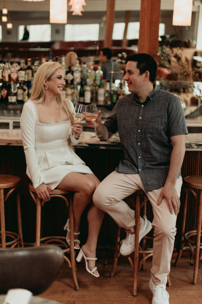 Engagement Session at Goodnight Restaurant toasting with wine at the bar.