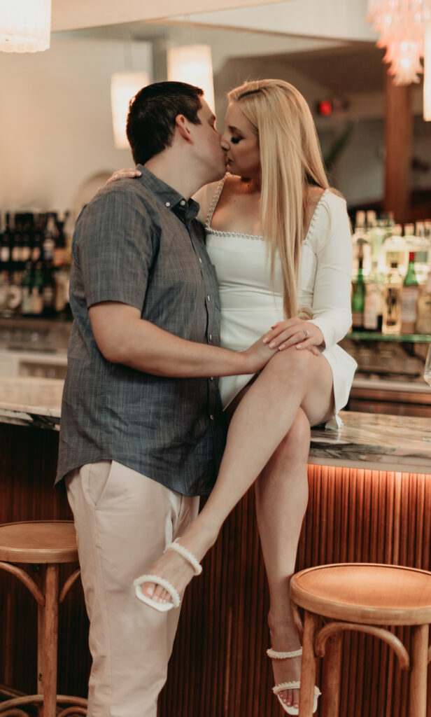 toasting with wine at the bar. sharing a kiss. modern moody photography