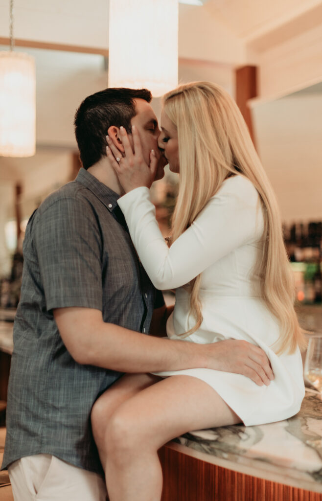 Engagement Session at Goodnight Restaurant toasting with wine at the bar. sharing a kiss. modern moody photography