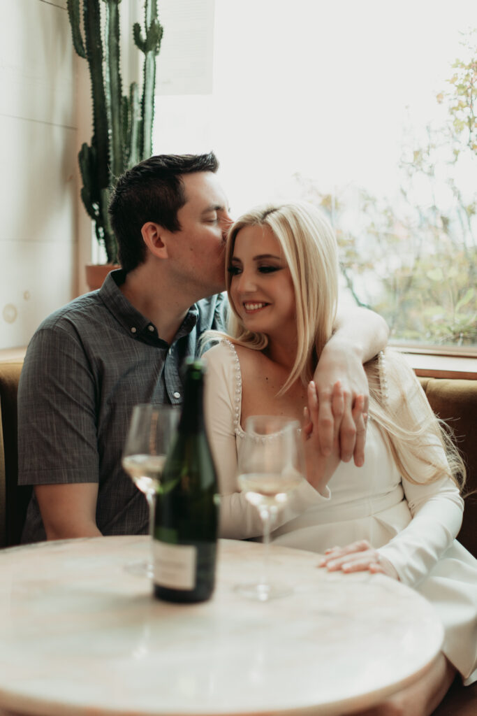 toasting with wine at the bar. sharing a kiss. modern moody photography