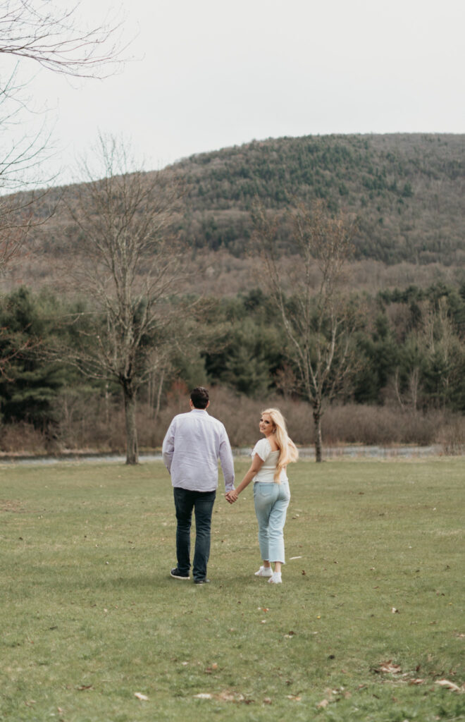 Engagement Session at Kenneth L. Wilson Campground. Woodstock, NY. couple walking away from camera. beautiful landscape, bride looks back smiling