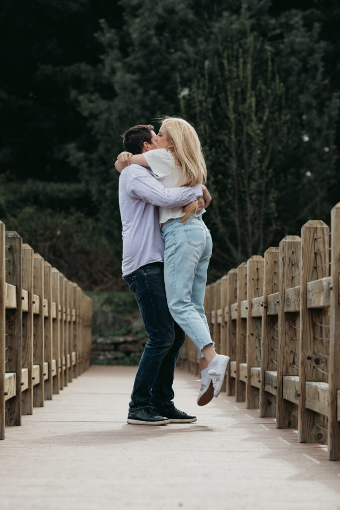 Engagement Session at Kenneth L. Wilson Campground. Woodstock, NY. couple walking on bridge. beautiful landscape, grooms picks up bride. couple locked in embrace.