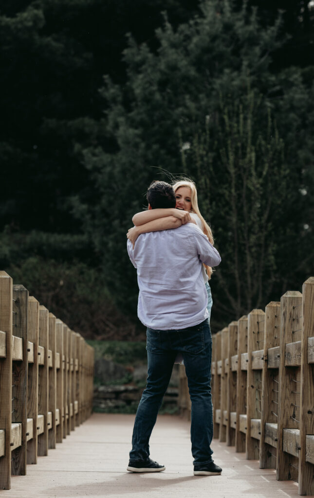 Engagement Session at Kenneth L. Wilson Campground. Woodstock, NY. couple walking on bridge. beautiful landscape, grooms picks up bride. couple locked in embrace.