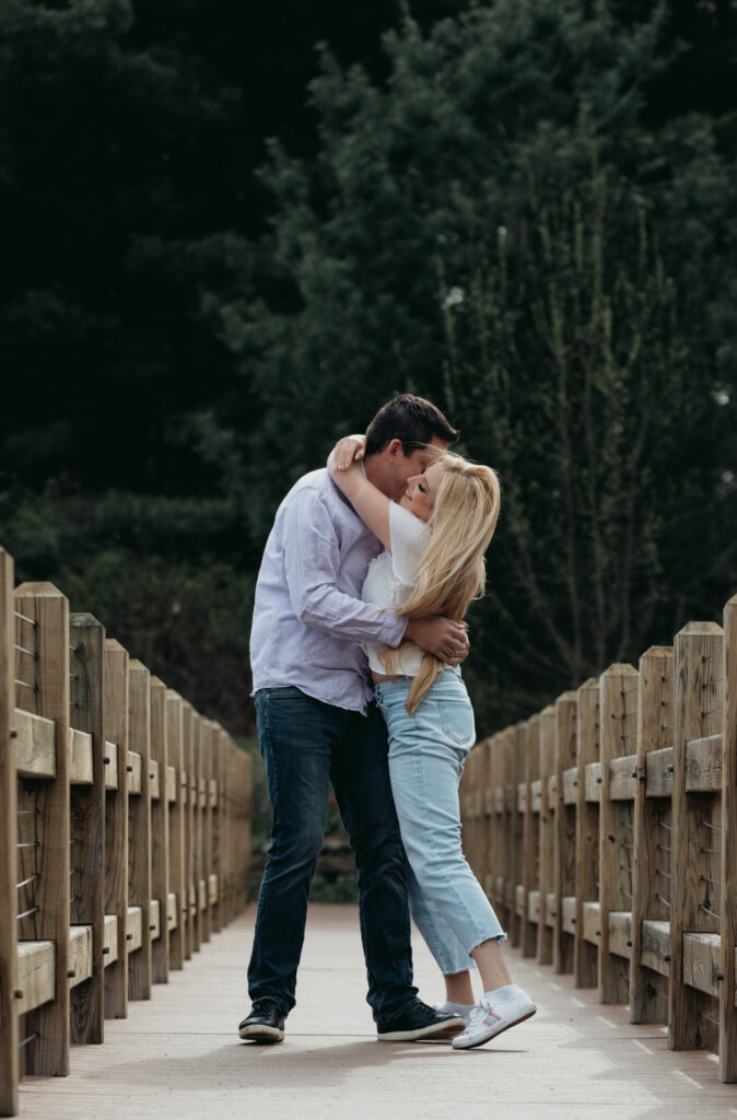 Engagement Session at Kenneth L. Wilson Campground. Woodstock, NY. couple walking on bridge. beautiful landscape, grooms picks up bride. couple locked in embrace.