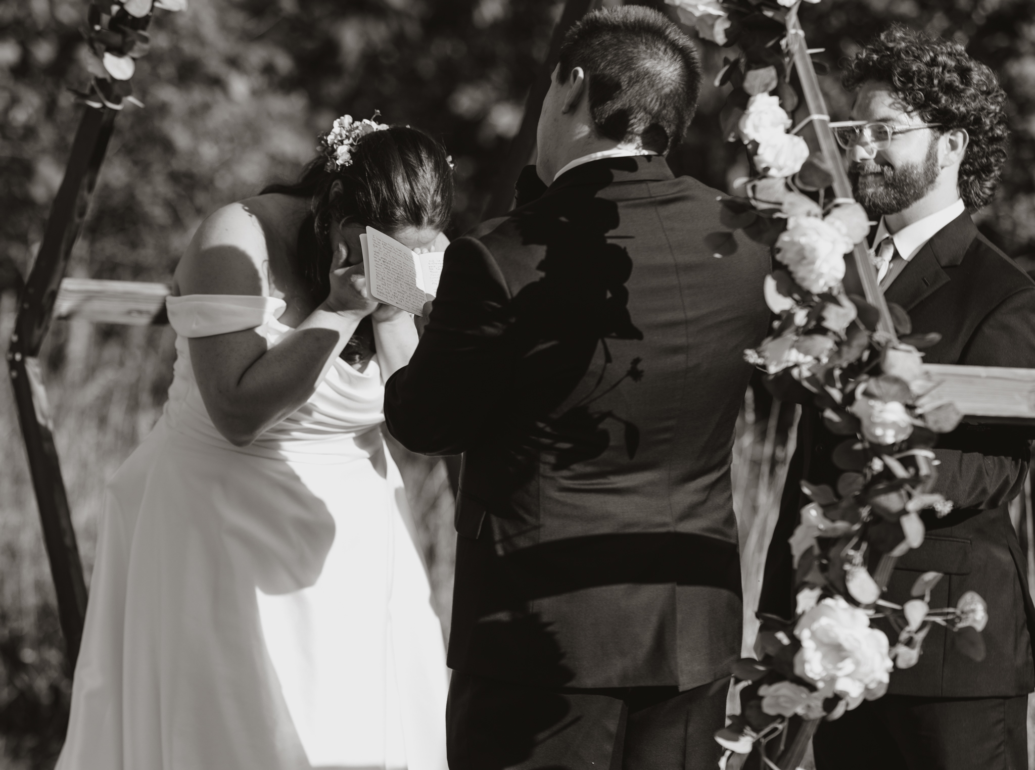 black and white photo of bride crying during ceremony vows.