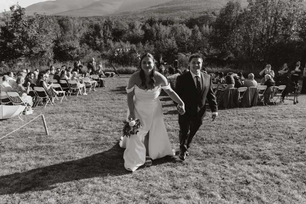 black and white shot of the couple walking away from the ceremony space