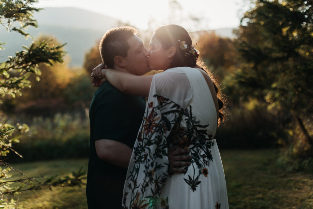 golden hour portraits in the family back yard. intimate wedding in round top new york close up of newly married couple kissing