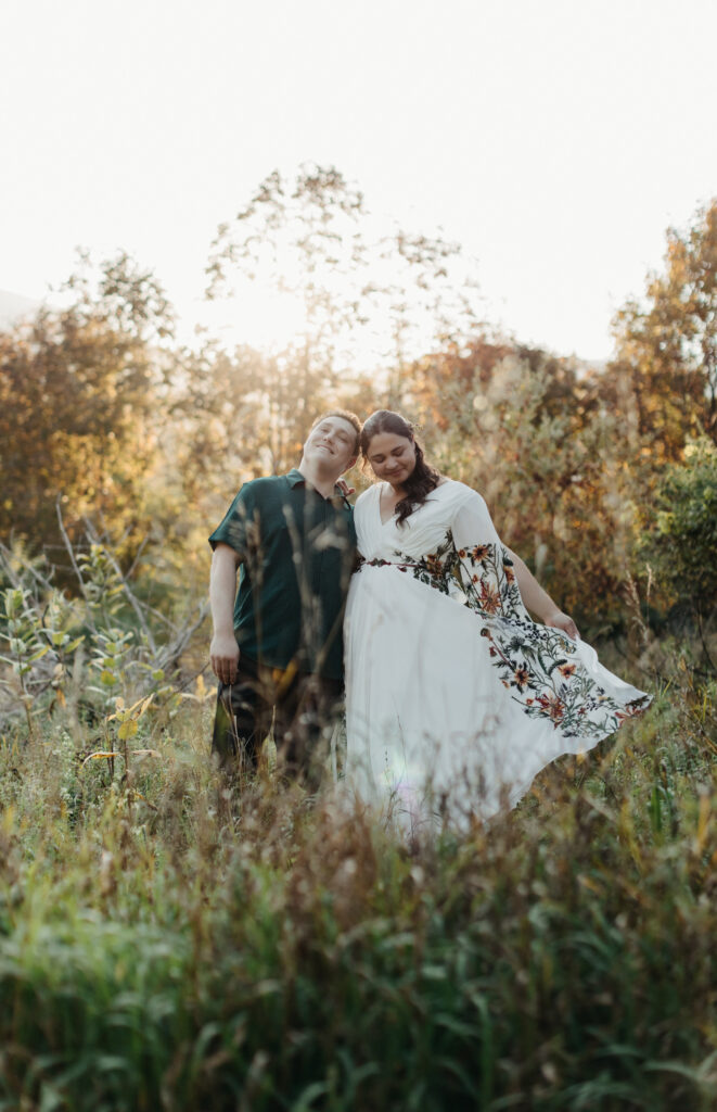 bride and groom walking in tall grass for their golden hour portrait session