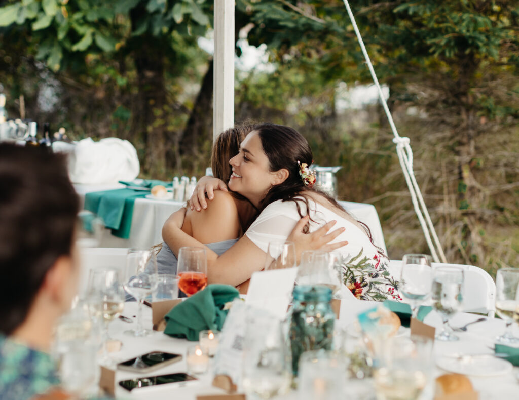 bride and maid of honor share a hug after her speech